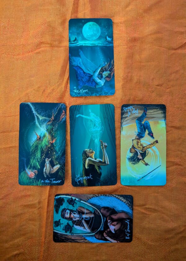 5 tarot cards in 3 rows, one on top, three in the middle and one sideways on the bottom